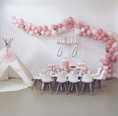 a pink and white birthday party with balloons