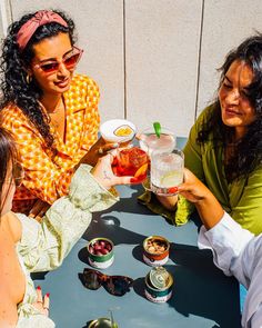 three women sitting at a table with drinks