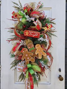 a christmas wreath with gingerbreads and candy canes hanging on the front door