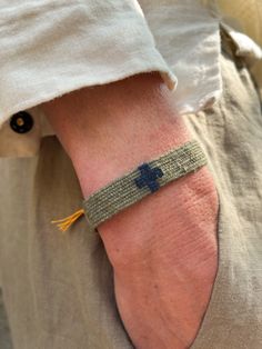 a person wearing a bracelet with a cross on it