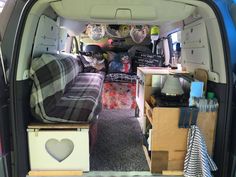 the inside of a van with many items in it and storage boxes on the floor