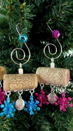 two wine corks are hanging from a christmas tree with colorful beads and charms on them