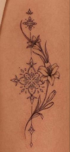 a woman's thigh with flowers and leaves tattoo on her side ribcage