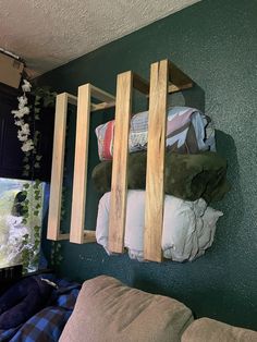 a living room filled with lots of furniture next to a wall mounted shelf on the side of a green wall