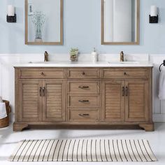 a bathroom vanity with two mirrors above it and a rug on the floor next to it