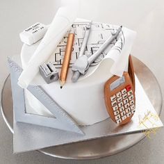 there is a cake that looks like it has construction drawings on it and a calculator next to it