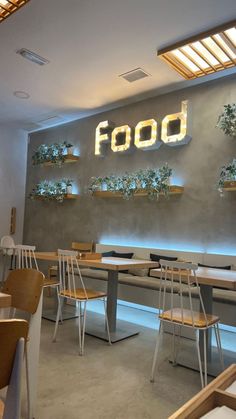 the interior of a restaurant with wooden tables and chairs in front of a sign that says food