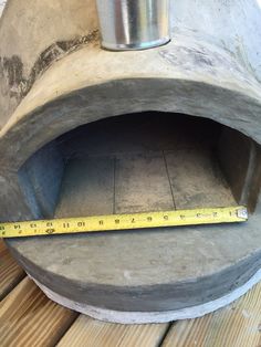 a large metal object with a measuring tape on it's side and a piece of wood in front of it