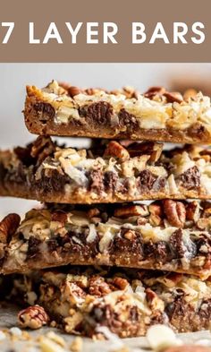 seven layer bars stacked on top of each other with nuts and chocolate in the middle