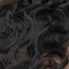 the top part of a woman's head with wavy hair on it, close up