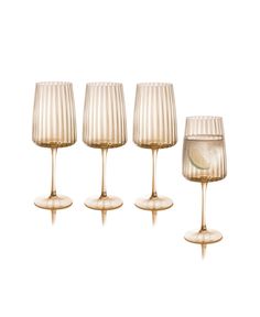 four wine glasses are lined up in a row