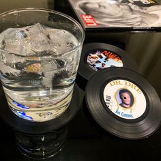 a glass filled with ice sitting on top of a table next to an album cover