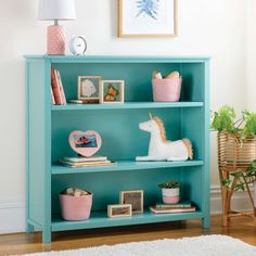 a blue bookcase with pictures and toys on it