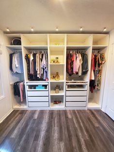 an organized closet with white drawers and hanging clothes