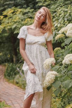 Product Details Embrace a blend of elegance and romance with our Kaylin Empire Waist Textured Flower Midi Dress. This white midi dress features 3D floral embroidery lace detailing and a square neckline lined with delicate lace. Subtle puff sleeves and a flattering babydoll fit complete the look, making it perfect for any special occasion. Babydoll design High-waisted White textured flowers Smocked at back The Fabric 100% Cotton Lining: 100% polyster Hand-wash, lay flat to dry Fit Guide Dara Size Flower Midi Dress, Holiday Soiree, Nature Photoshoot, Floral Cotton Dress, Photoshoot Dress, White Midi, White Floral Dress, Embroidery Lace, Dresses By Length