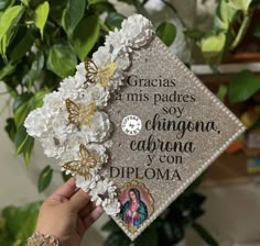 someone is holding up a graduation cap that has flowers on it and the words gracias, miss pages, soy, chiquina, california y con diploma