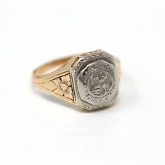 Lovely antique dated 1927 Art Deco era 14k yellow and white gold signet ring! This stylish statement ring is is adorned with floral designs on each shoulder. The ring face reads Minneapolis High School with a school emblem on the front. The inside of the ring band is sweetly engraved 'L.E.J. - 27.' A fantastic piece of fine Art Deco era dated jewelry! *Sale - price reduced from $425 USD to $395 USD.  ERA - Dated 1927 - Art Deco  METAL / MATERIAL - 14k yellow & white gold MARKINGS / HISTORY - Ins School Emblem, Art Deco Metal, The Ring Face, Face Reading, Logo Gifts, Gold Signet Ring, White Gold Band, Art Deco Era, Flower Jewelry