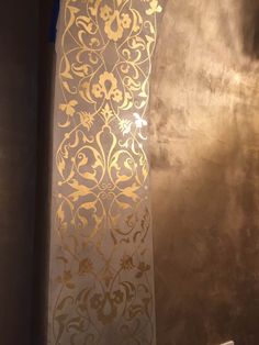 an ornate gold and white wallpaper in a room with metallic foil on the walls