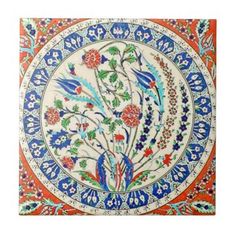 a decorative tile with flowers and leaves on it's surface, in red, blue,