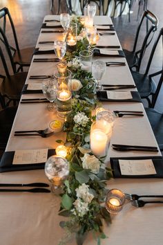 a long table is set with candles and place settings for dinner guests to sit at