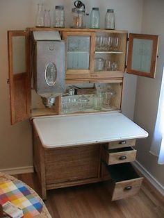 an old fashioned kitchen with lots of glassware on the cupboards and shelves in it