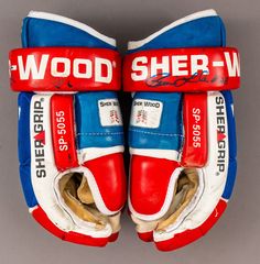 two pairs of red, white and blue baseball gloves with the words wood sher - w on them