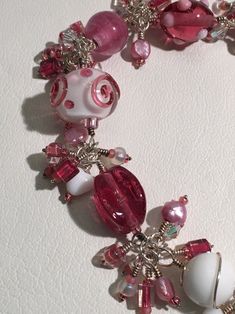 a close up of a bracelet with beads and charms