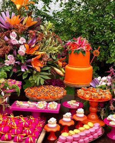 a table topped with lots of colorful cakes and cupcakes