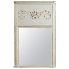 a white wall mirror sitting on top of a wooden frame