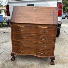 a wooden dresser sitting in front of a white truck