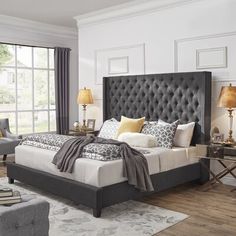 a large bed sitting in a bedroom on top of a hard wood floor next to a window