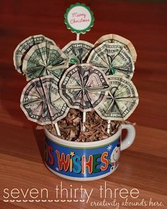 a cup filled with money sitting on top of a wooden table