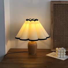 a lamp that is on top of a table next to a book and some balls