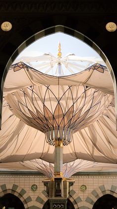 the inside of a building with an arch and ceiling covered in white draping