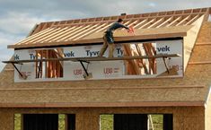 a man is working on the roof of a house under construction with wood shingles