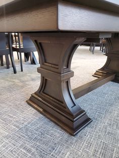 a dining room table with chairs around it and carpeted flooring on the other side