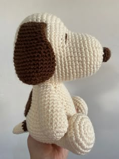 a crocheted stuffed dog is held in the palm of a person's hand