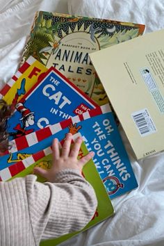 a child is playing with books on the bed