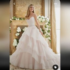 a woman in a wedding dress standing next to a fireplace