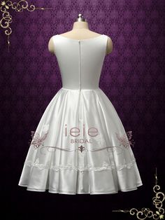 a white wedding dress on a mannequin with purple wallpaper in the background