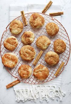 cinnamon sugar donuts on a wire rack with cinnamon sticks and cinnamon sticks next to them