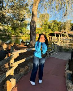 a woman standing on a walkway covering her mouth