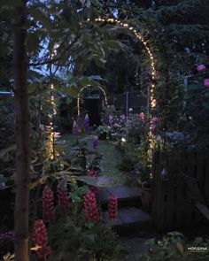 the garden is lit up with fairy lights and lush greenery, as well as pink flowers