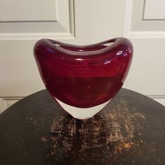 a red and white vase sitting on top of a table