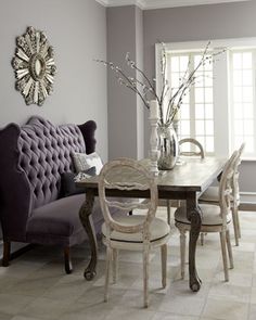 a dining room table with chairs and a bench in front of the mirror on the wall