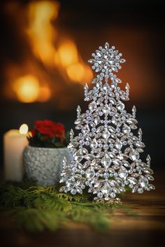 a small crystal christmas tree next to a candle