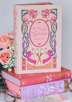 three books stacked on top of each other next to some flowers and a pocket watch