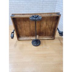 an old wooden box sitting on top of a hard wood floor next to a brick wall