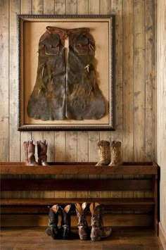 two pairs of shoes are sitting on a bench in front of a painting