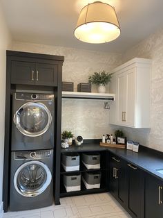 a washer and dryer sitting in a kitchen next to each other on top of cabinets